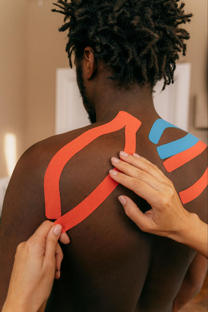 Person Applying Tape to Another’s Back