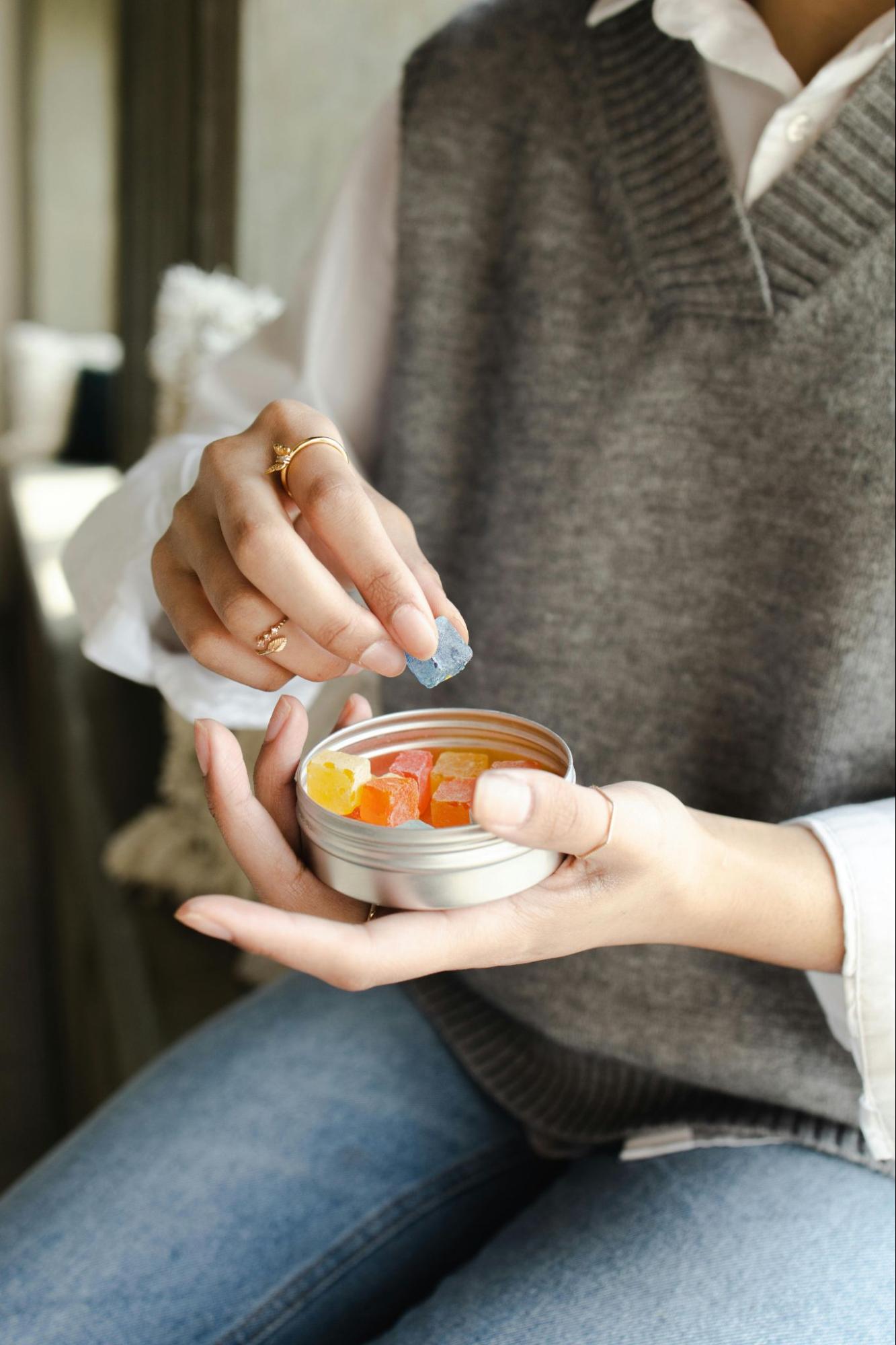 Woman Taking a Gummy out of a Container