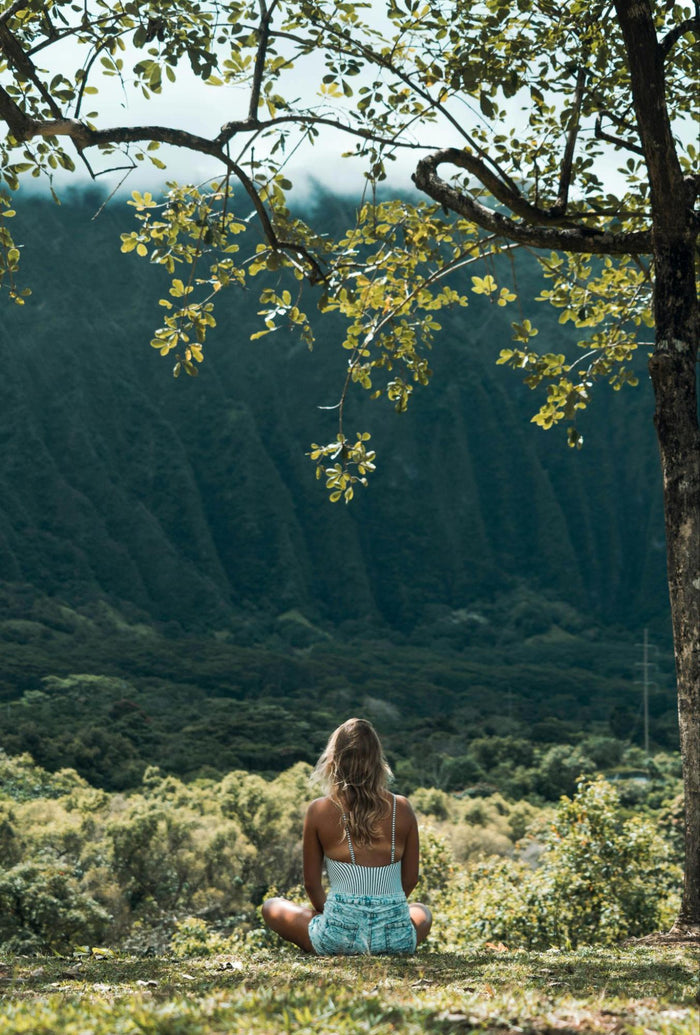 Woman Sitting Looking at Green Hills