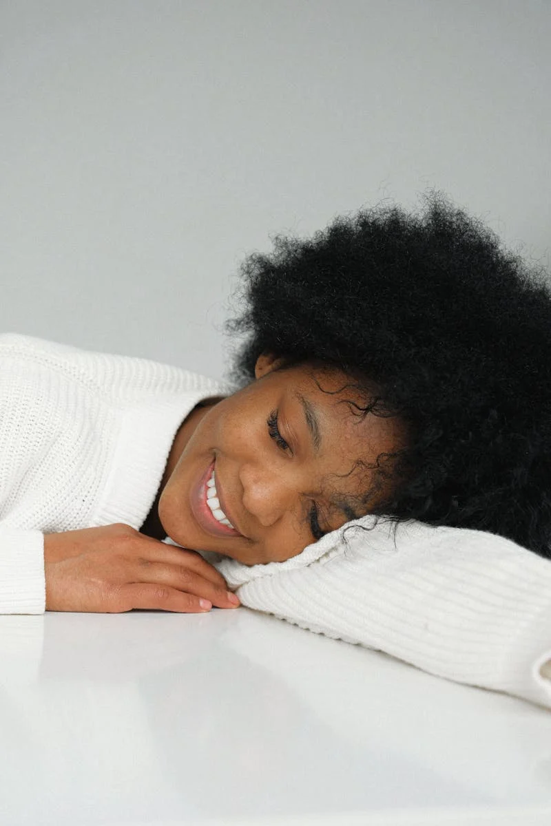 Woman in White Lying on Pillow Smiling