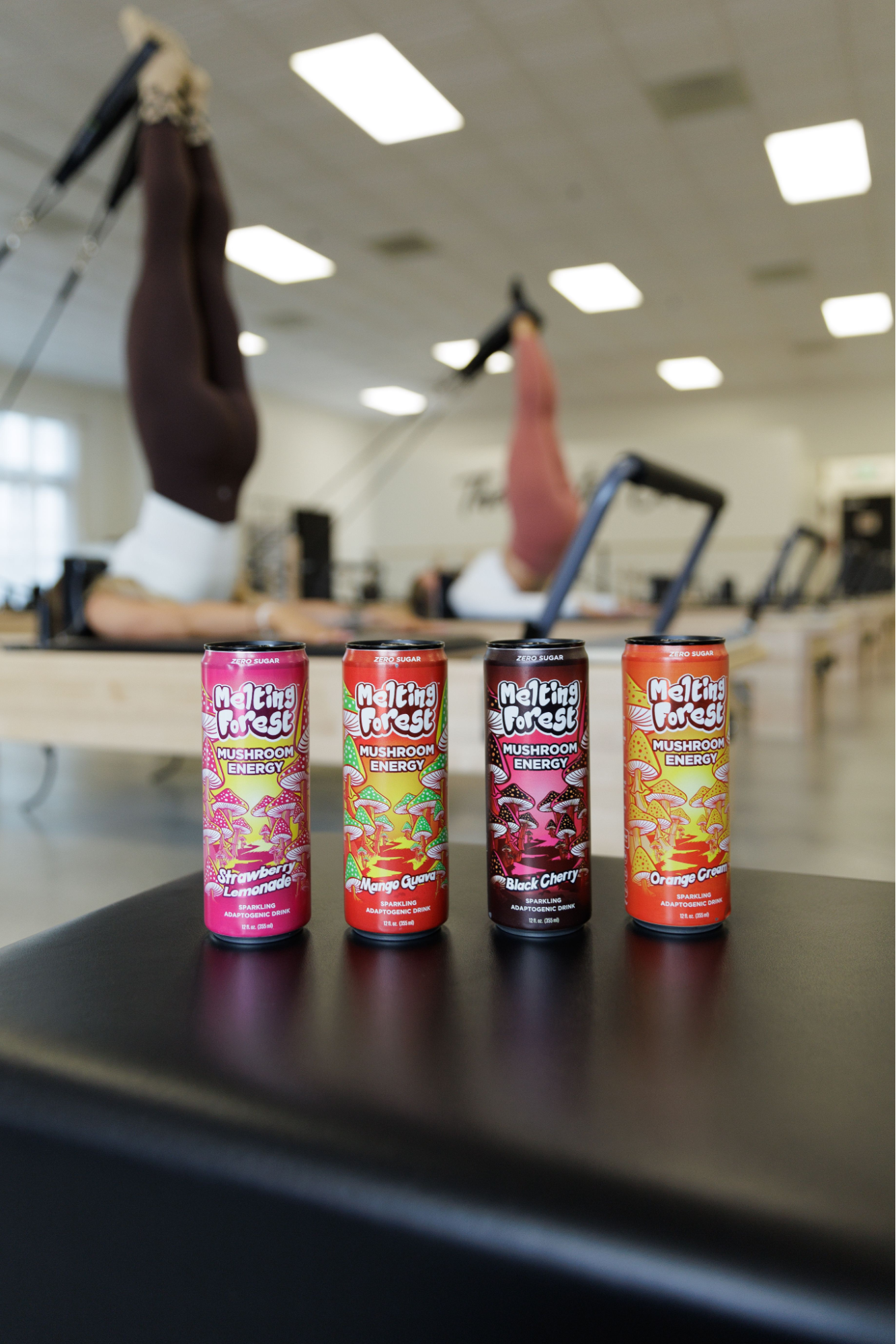 Four mushroom drinks in line on a black surface