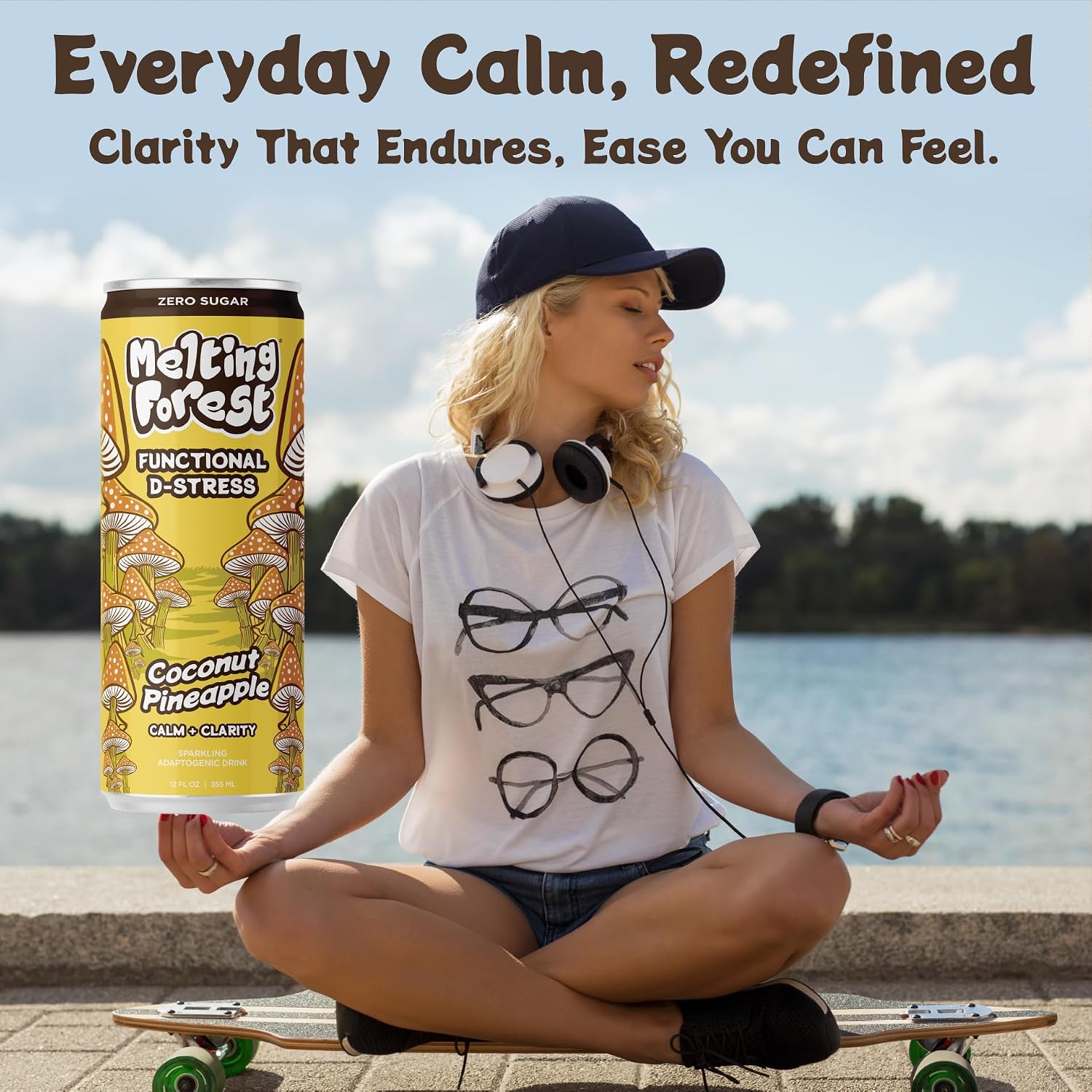 A woman sits cross-legged on a skateboard by the water, eyes closed with headphones and a cap. Next to her is a can of Mushroom D-Stress Drink 12 pack – Coconut Pineapple. Text above: "Everyday Calm, Redefined—the ultimate stress relief drink.
